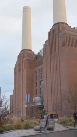 Vertikales-Video,-Das-Die-Außenansicht-Der-Battersea-Kraftwerksentwicklung-In-London,-Großbritannien,-Mit-Personen-Zeigt-1